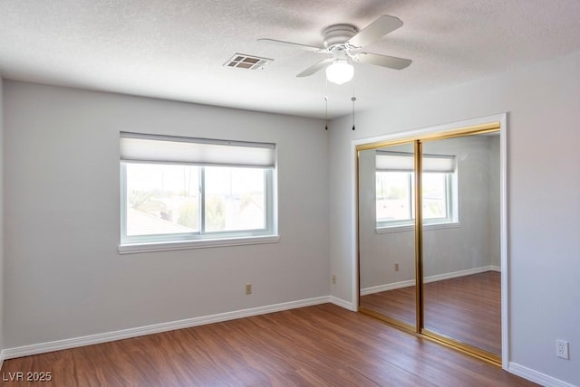 3008 Blue Fin Cir, Las Vegas, NV 89128 - unfurnished bedroom featuring wood finished floors, a closet, a textured ceiling, baseboards, and ceiling fan