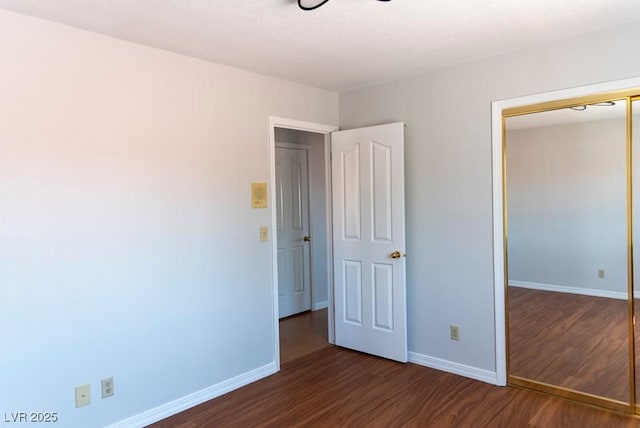 3008 Blue Fin Cir, Las Vegas, NV 89128 - unfurnished bedroom with dark wood-type flooring, baseboards, and a closet