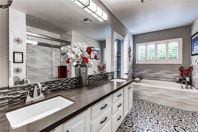 full bath with visible vents, a sink, a garden tub, and a stall shower