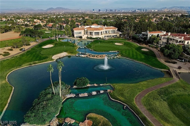 drone / aerial view with view of golf course and a water and mountain view
