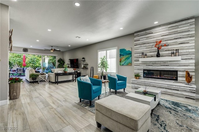 living room featuring recessed lighting, ceiling fan, wood finished floors, and a tile fireplace