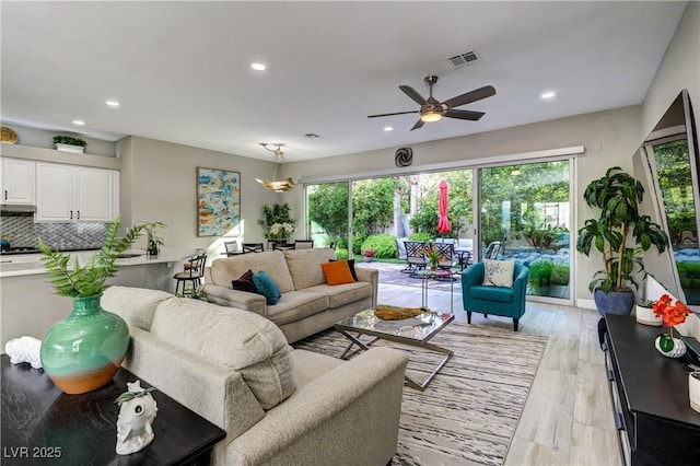 living room featuring recessed lighting, visible vents, and a wealth of natural light