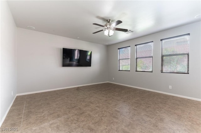 spare room with baseboards, ceiling fan, and visible vents