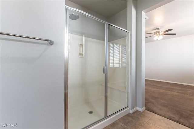 bathroom featuring baseboards, a ceiling fan, tile patterned floors, and a shower stall