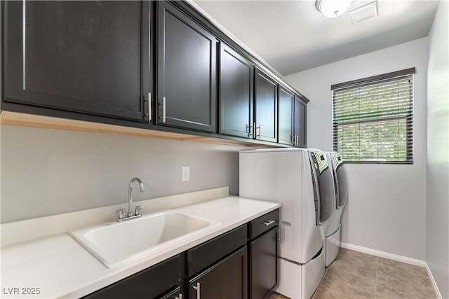 washroom with washer and dryer, baseboards, a sink, and cabinet space