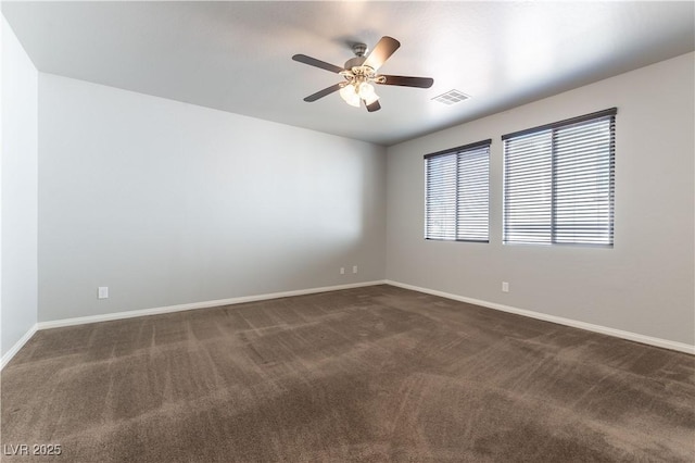 empty room featuring dark colored carpet, baseboards, ceiling fan, and visible vents