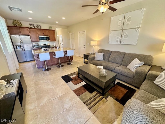 living room with a ceiling fan, visible vents, light tile patterned floors, and recessed lighting