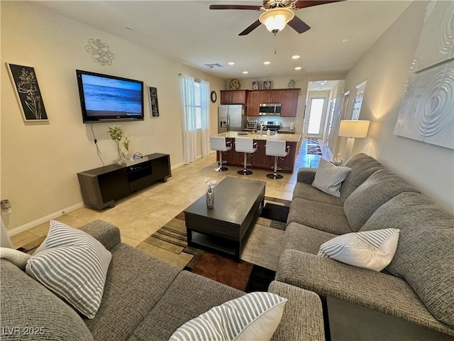 living area featuring a ceiling fan, baseboards, recessed lighting, and light tile patterned flooring