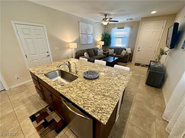 kitchen featuring stainless steel dishwasher, a sink, ceiling fan, and light tile patterned floors