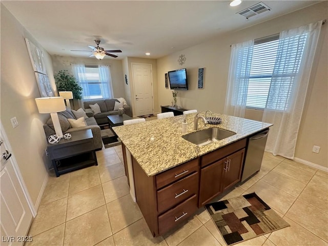 kitchen with stainless steel dishwasher, visible vents, light tile patterned flooring, ceiling fan, and a sink