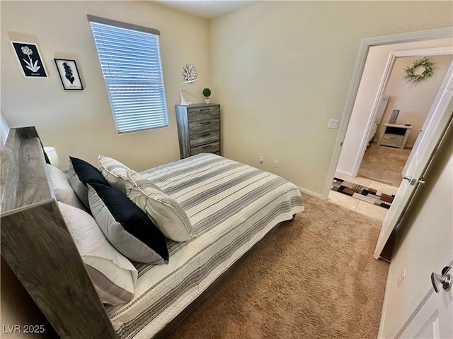bedroom featuring baseboards, light colored carpet, and light tile patterned floors