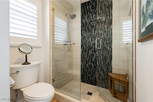 full bath featuring a stall shower and toilet