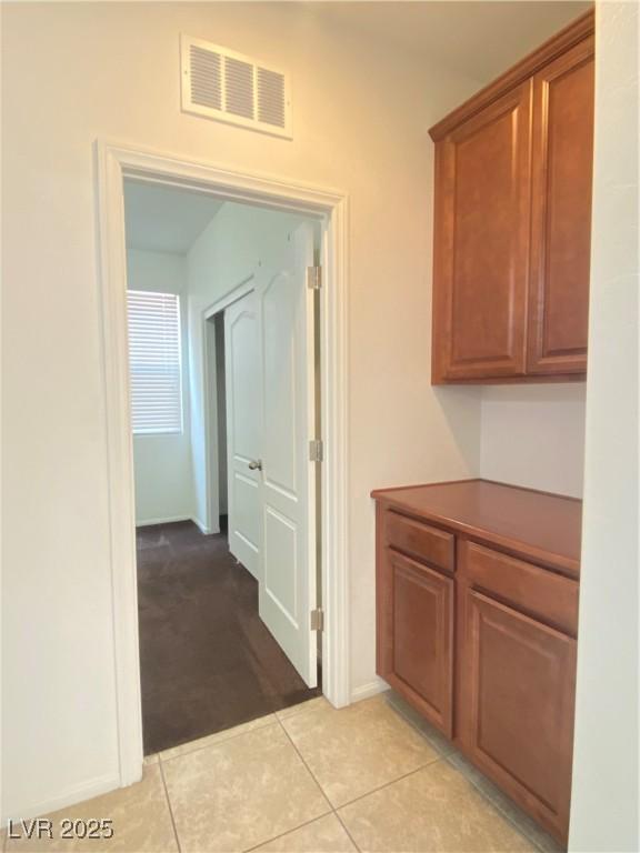 5513 Silent Springs Dr, Las Vegas, NV 89122 - hallway featuring baseboards, light carpet, light tile patterned flooring, and visible vents
