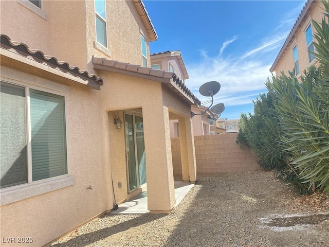 5513 Silent Springs Dr, Las Vegas, NV 89122 - view of side of home with a patio area, stucco siding, and fence