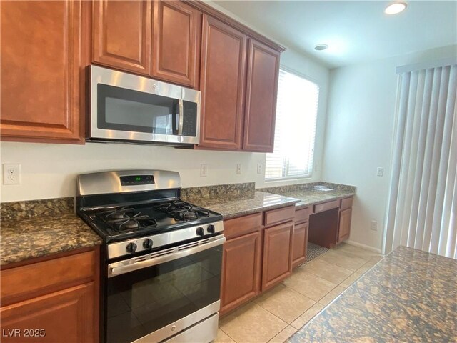 5513 Silent Springs Dr, Las Vegas, NV 89122 - kitchen featuring recessed lighting, dark stone counters, appliances with stainless steel finishes, and light tile patterned flooring