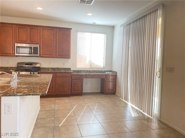 5513 Silent Springs Dr, Las Vegas, NV 89122 - kitchen featuring light tile patterned flooring, recessed lighting, dark stone counters, a sink, and stainless steel appliances