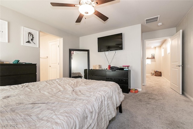 carpeted bedroom with baseboards, a ceiling fan, and visible vents
