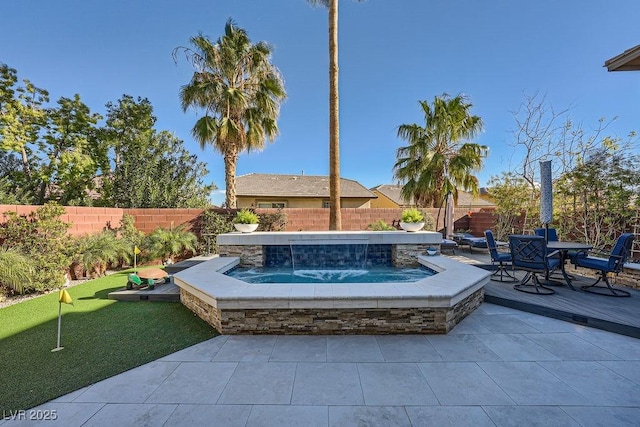 view of patio featuring a hot tub, a fenced backyard, and outdoor dining space