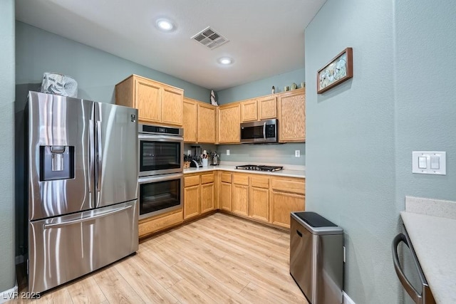 kitchen with visible vents, light countertops, light wood-style floors, stainless steel appliances, and recessed lighting
