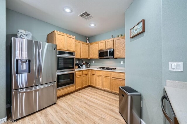 5442 Bristol Bend Ct, Las Vegas, NV 89135 - kitchen with visible vents, light countertops, light wood-style floors, stainless steel appliances, and recessed lighting