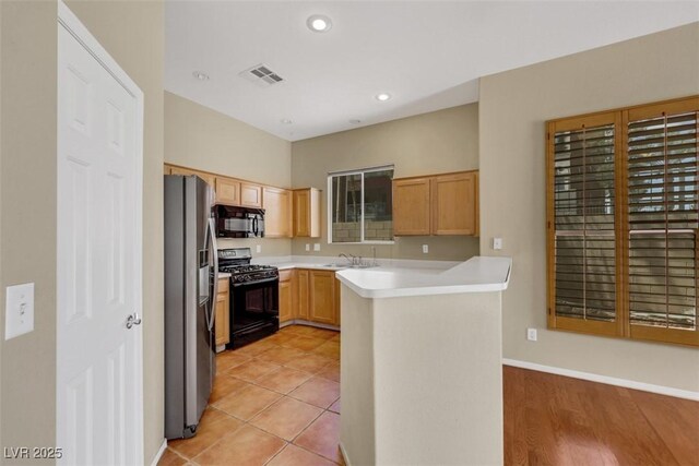 kitchen with visible vents, light countertops, black appliances, a peninsula, and recessed lighting