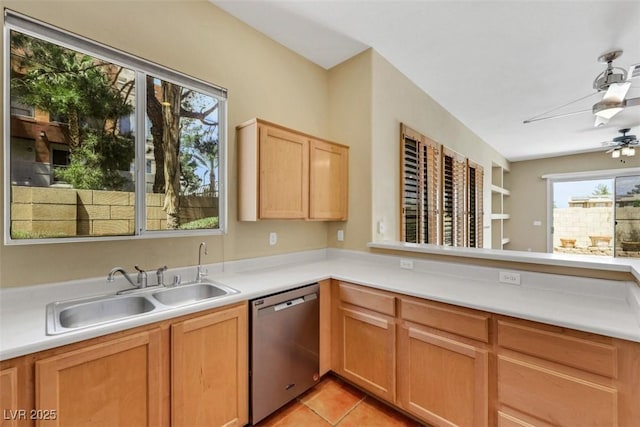 kitchen featuring ceiling fan, dishwasher, a sink, light countertops, and light tile patterned floors