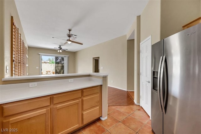 kitchen featuring light tile patterned floors, stainless steel fridge with ice dispenser, ceiling fan, and light countertops