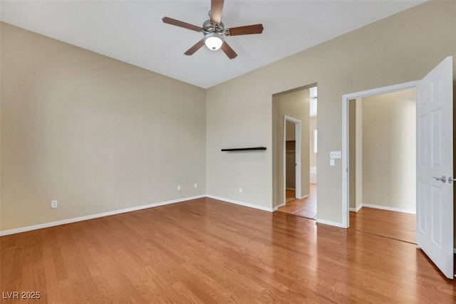 spare room with baseboards, ceiling fan, and wood finished floors