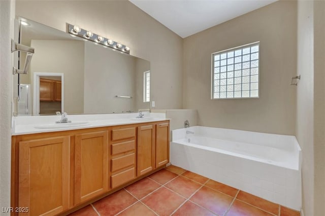 bathroom featuring a garden tub, a sink, tile patterned floors, and double vanity