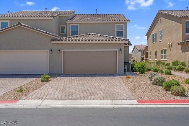 946 Belton Lake Ave, North Las Vegas, NV 89086 - view of front of home with stucco siding, an attached garage, a tile roof, and decorative driveway