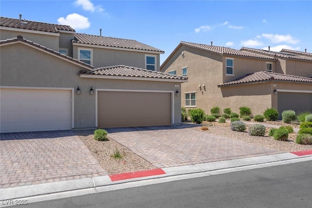 946 Belton Lake Ave, North Las Vegas, NV 89086 - view of front of property with a garage, decorative driveway, stucco siding, and a tiled roof