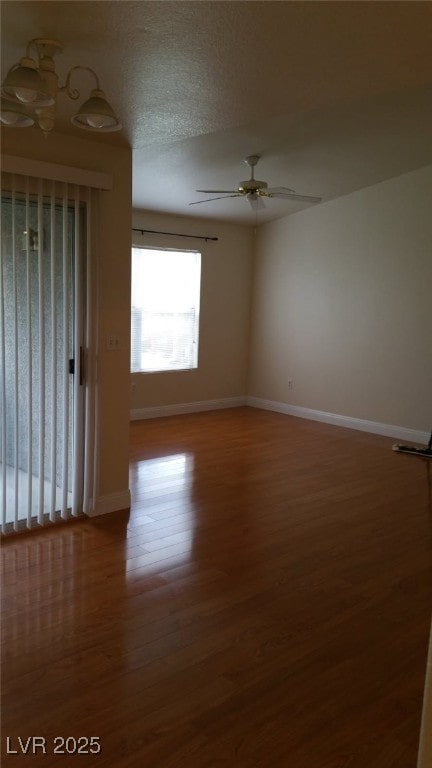 spare room featuring baseboards, a ceiling fan, and wood finished floors