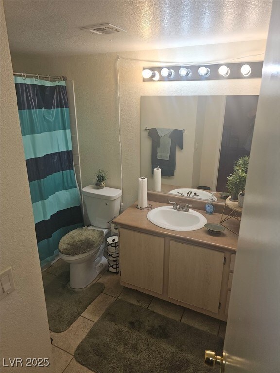 555 E Silverado Ranch Blvd Unit 2028, Las Vegas, NV 89183 - bathroom featuring tile patterned floors, vanity, a textured ceiling, toilet, and a shower with curtain