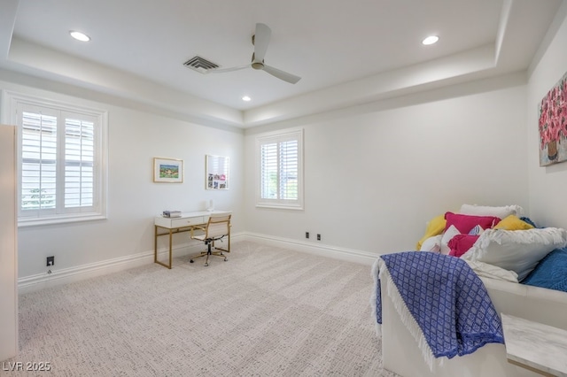 carpeted bedroom featuring recessed lighting, a tray ceiling, visible vents, and baseboards