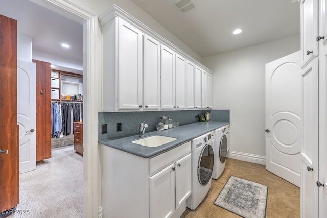 laundry area with washing machine and clothes dryer, cabinet space, a sink, recessed lighting, and visible vents