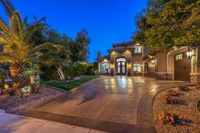 mediterranean / spanish home featuring stucco siding, french doors, and stone siding