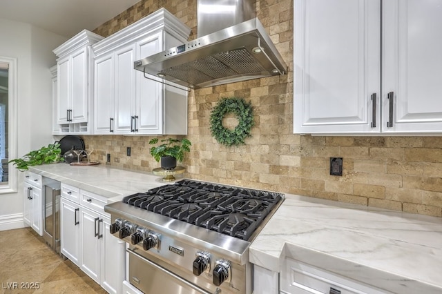 kitchen featuring exhaust hood, white cabinets, light stone countertops, stainless steel gas stovetop, and tasteful backsplash
