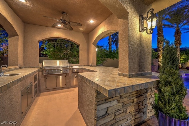 view of patio / terrace with a sink, exterior kitchen, a ceiling fan, and area for grilling
