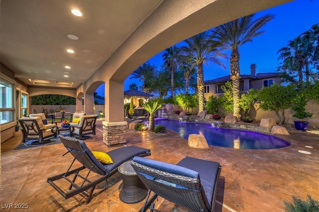 patio at night featuring a fenced in pool, an outdoor hangout area, and a fenced backyard