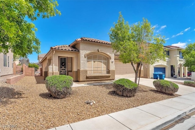 mediterranean / spanish-style house with fence, an attached garage, a tile roof, stucco siding, and concrete driveway