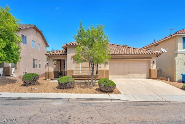 mediterranean / spanish home featuring an attached garage, stucco siding, a tile roof, and concrete driveway