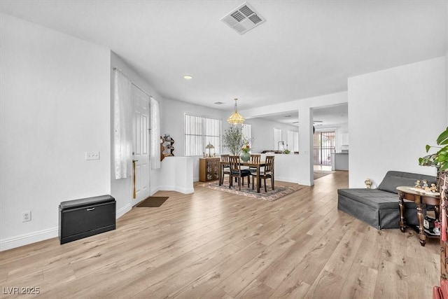 living room featuring light wood-style floors, baseboards, recessed lighting, and visible vents