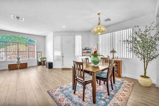 dining room featuring visible vents, baseboards, and light wood-type flooring