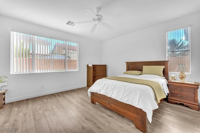 bedroom with baseboards, a ceiling fan, wood finished floors, and visible vents