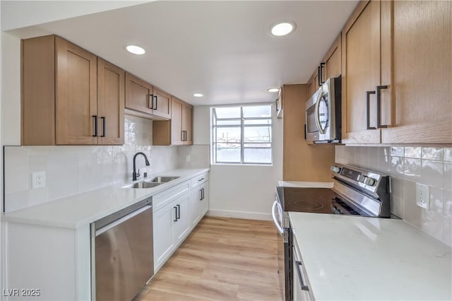 kitchen featuring baseboards, recessed lighting, a sink, backsplash, and stainless steel appliances