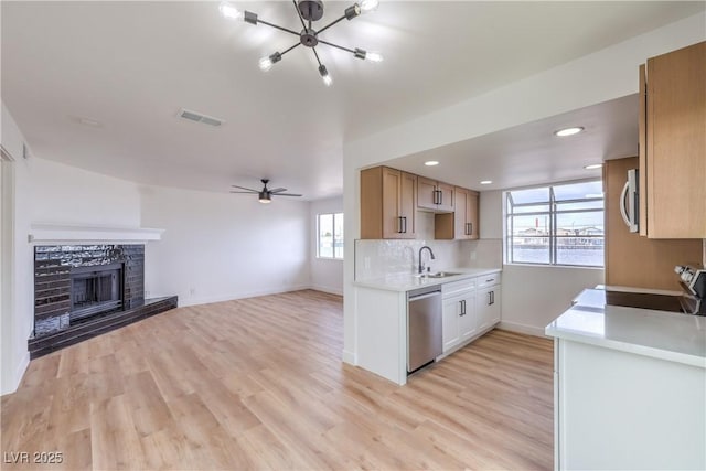 kitchen with visible vents, baseboards, light countertops, a sink, and appliances with stainless steel finishes
