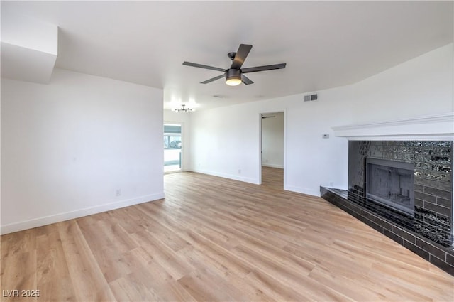 unfurnished living room featuring ceiling fan, baseboards, light wood finished floors, and a tile fireplace