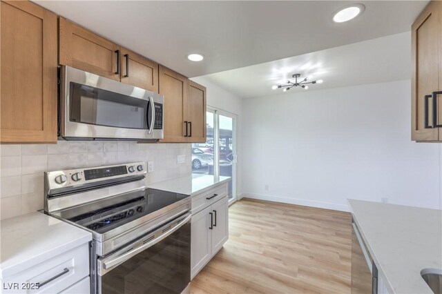 kitchen featuring light countertops, decorative backsplash, and stainless steel appliances