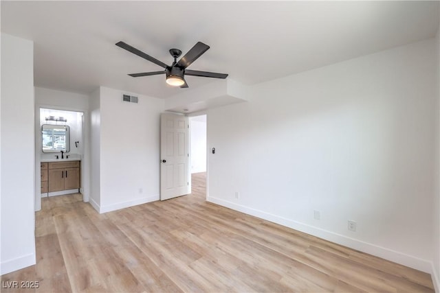 unfurnished bedroom with baseboards, visible vents, ensuite bathroom, and light wood-style floors