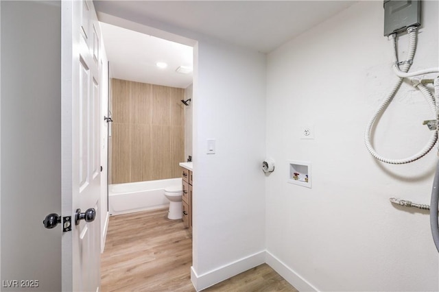 laundry area featuring laundry area, hookup for a washing machine, light wood-style flooring, baseboards, and hookup for an electric dryer